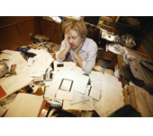 Picture of a man surrounded by a pile of papers